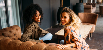 Deux femmes rigolent sur un canapé