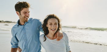Un couple rigole au bord de la mer