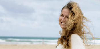 une femme sourit au bord de la mer