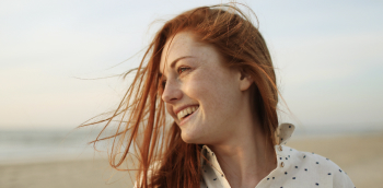 une femme sourit au bord de la mer