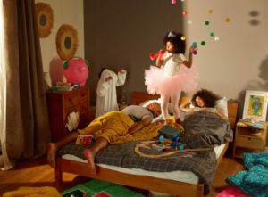 Deux enfants font des bêtises dans la chambre de leurs parents pendant que ces derniers essaient de dormir.